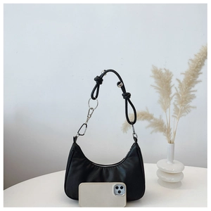 Detail of black half-moon shoulder bag with knotted strap, metal ring and zipper closure