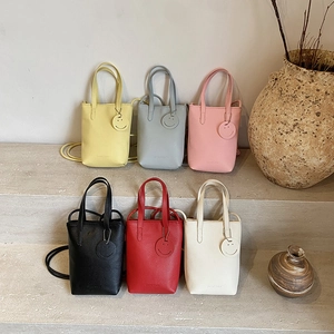Minimalist leather tote bag with smile pendant in six colors for versatile commuting