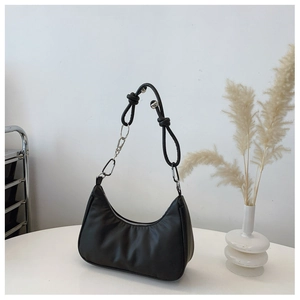 Détail du sac croissant noir avec bandoulière en corde et boucle métallique argentée