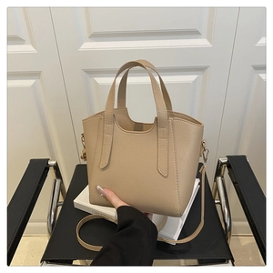 Dettagli della borsa a secchiello beige con grana litchi e manici doppi metallici
