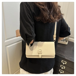 Off-white textured rectangle crossbody bag with gold hardware shown on a model