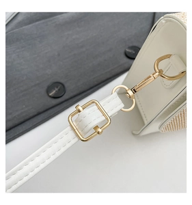 Detail of white leather shoulder strap with gold-plated metal buckle and stitching