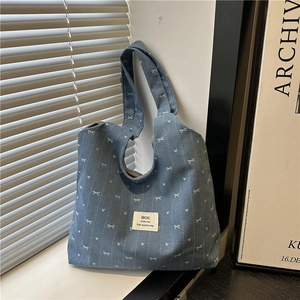 Casual denim tote bag with white bow heart prints on a minimalist window background