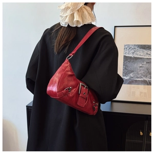 Détail du sac hobo rouge cerise style Maillard avec boucles sur cuir brillant