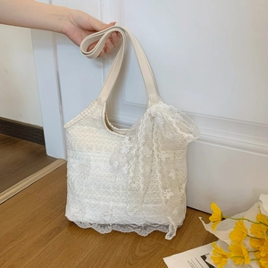 Elegant beige lace tote bag with hollow floral patterns and a large bow for summer beach