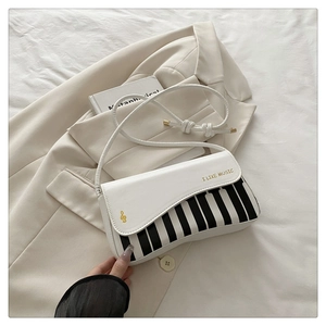 Close-up of stylish piano key stripe pattern and golden musical note decor on handbag