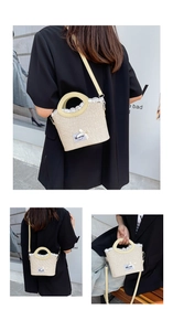 Close-up of beige woven bucket bag with white lace trim and blue label detail