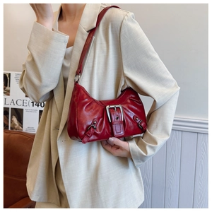 Détail du sac à bandoulière rouge en croissant avec boucle métallique et finitions argentées