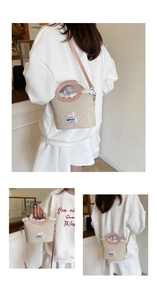 Detail of woven straw bucket bag featuring white lace trim and pink bow embellishment