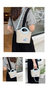 Detail of light beige woven bucket bag with blue leather handle and white lace trim