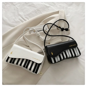 Detail of music-themed bag featuring piano key patterns and I Like Music text print
