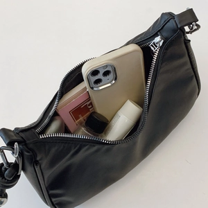 Black minimalist underarm dumpling bag in matte PU leather with silver zipper detail