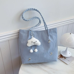Light blue pleated tote bag with metal butterflies and white plush cloud pendant