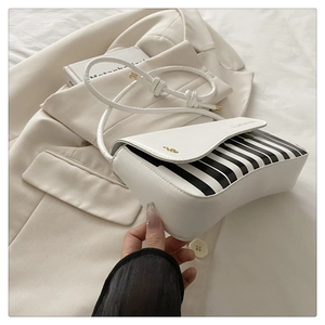 Detail of piano key design on white crossbody bag with gold music symbol and I LOVE MUSIC text