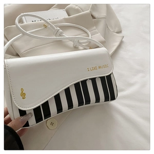 Detailed shot of music-themed bag with piano key pattern and golden treble clef