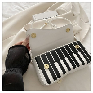 Detailed view of piano key handbag on blazer with golden magnetic snap fasteners