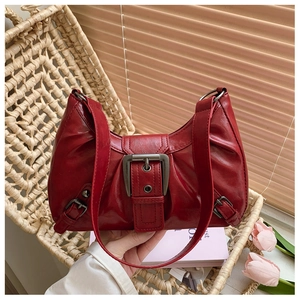 Détail du sac à bandoulière en cuir rouge brillant avec boucle argentée rétro chic