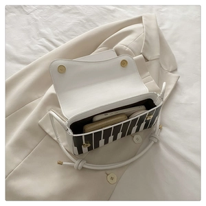Interior view of piano key crossbody bag showing storage for phone and wallet