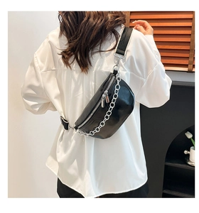 Detail of glossy black waist bag with chunky silver chain and adjustable wide shoulder strap