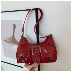 Détail du sac vintage rouge foncé en cuir brillant avec boucle argentée élégante