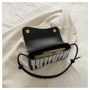 Top-down view of black and white piano key crossbody bag showing inner space for essentials