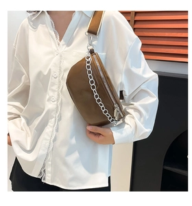 Detail of dark brown PU chest bag with silver chain decoration and wide shoulder strap