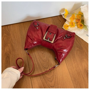 Détail du sac demi-lune en cuir rouge vieilli avec boucle argentée au style Y2K