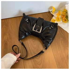 Détail du sac demi-lune noir vintage avec texture brillante et boucles argentées