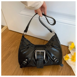 Détail du sac demi-lune en cuir PU noir brillant avec boucle argentée et finitions métal