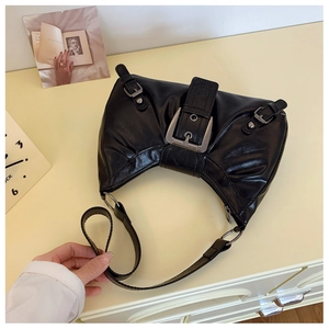 Détail du sac croissant noir avec boucle argentée vintage et texture brillante en gros plan