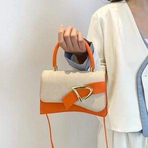 Minimalist beige woven and orange leather crossbody bag with golden D-buckle closure