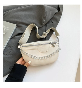 Detail of off-white fanny pack with silver chain and wide adjustable strap on a blazer
