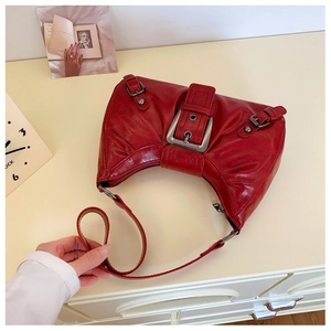 Détail du sac à bandoulière en cuir rouge brillant vintage avec boucle en métal argenté