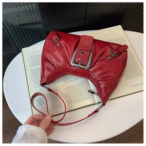 Détail du sac demi-lune rouge en cuir vieilli avec boucle en métal au style rétro