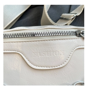 Nahaufnahme der weißen Leder-Brusttasche mit Fashion-Prägung und silbernem Metall-Reißverschluss
