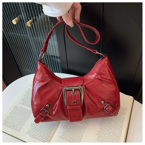 Détail d'un sac hobo rouge brillant avec boucle argentée sur fond vintage rétro