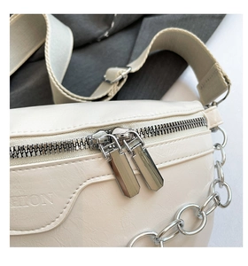Detailansicht der cremefarbenen Leder-Brusttasche mit Doppelreißverschluss und Fashion-Schrift