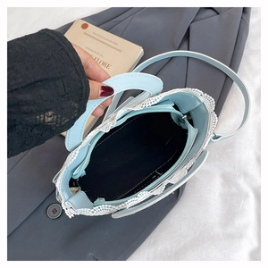 Détail du sac seau bleu clair en dentelle avec fermeture zippée et doublure noire