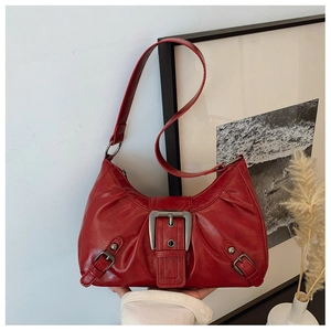 Détail du sac rouge vintage avec boucles argentées et texture en cuir plissé élégant