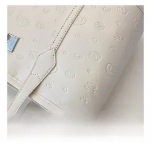 Gros plan du cabas blanc avec motifs embossés ludiques et détails de couture de précision