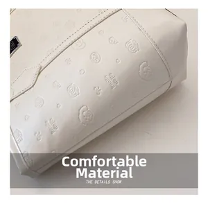 Gros plan détaillé du sac cabas en cuir gaufré blanc crème aux motifs mignons