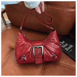 Gros plan sur le sac vintage rouge avec boucle argentée et texture de cuir froncé