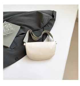 Minimalist creamy white leather crescent bag with adjustable wide fabric shoulder strap