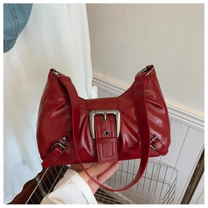 Détail du sac à bandoulière bordeaux vintage avec boucle argentée et texture rétro