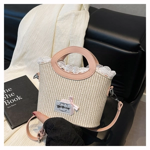 Détail d'un sac en paille tissé à la main avec dentelle et poignées en cuir rose