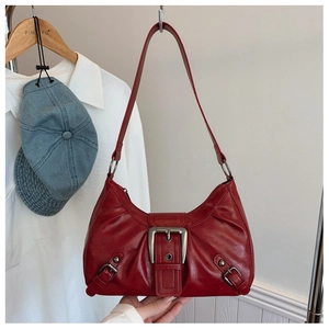 Détail du sac porté épaule vintage en cuir rouge avec boucle métal et aspect froissé
