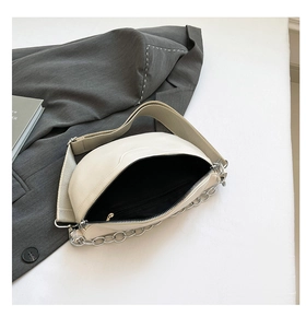 Detail view of cream white crescent bag showing inner zipper pocket and fabric strap