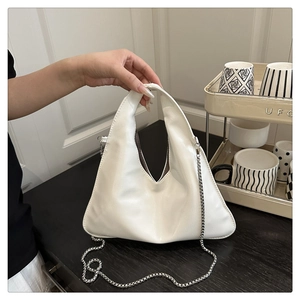 Detail of white PU leather triangular handbag with delicate metal chain strap for women