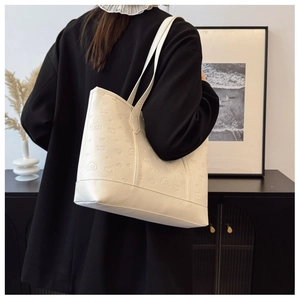 Detail of creamy white tote bag with embossed cartoon patterns and large capacity