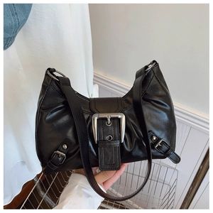 Détail d'un sac à bandoulière noir vintage avec texture plissée et boucle argentée